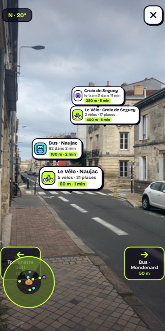 La réalité augmentée dans une rue de Bordeaux : les stations, vélos et bus posés dans leur direction, avec leur distance